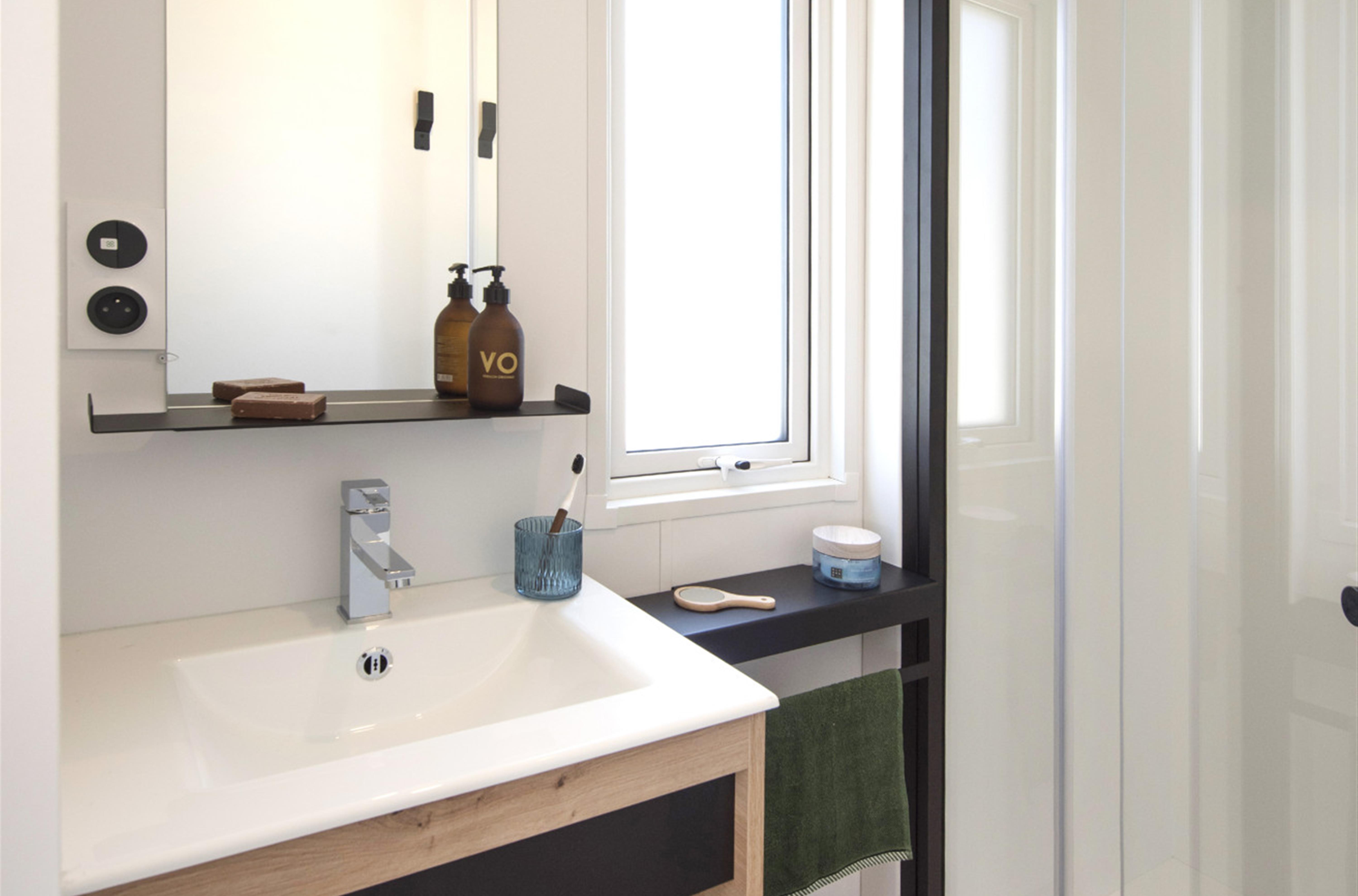 Bathroom with shower and washbasin in Campsite de la plage 29950 Benodet